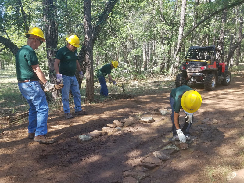 Adding rocks to correct a muddy area on Frog Tank connector trail
