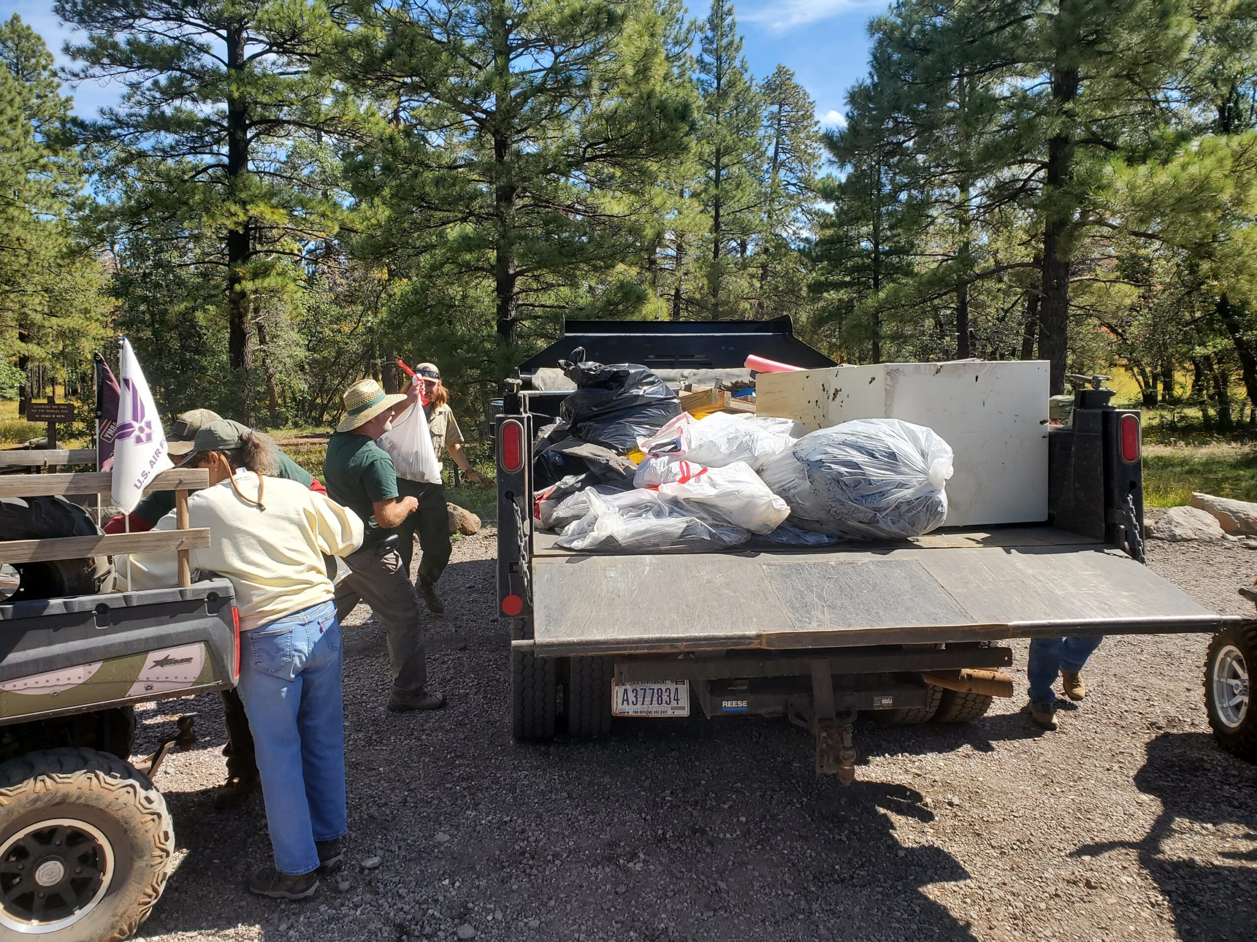Loading trash into Forest Service truck for delivery to dump.